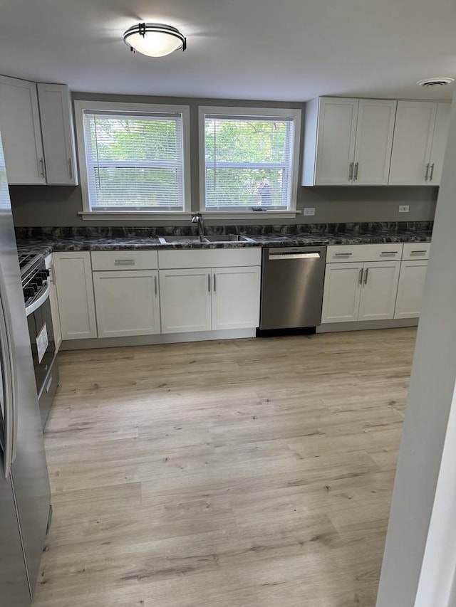 2407 Burbank St, Joliet, IL 60435 - kitchen with appliances with stainless steel finishes, a sink, healthy amount of natural light, and dark stone counters