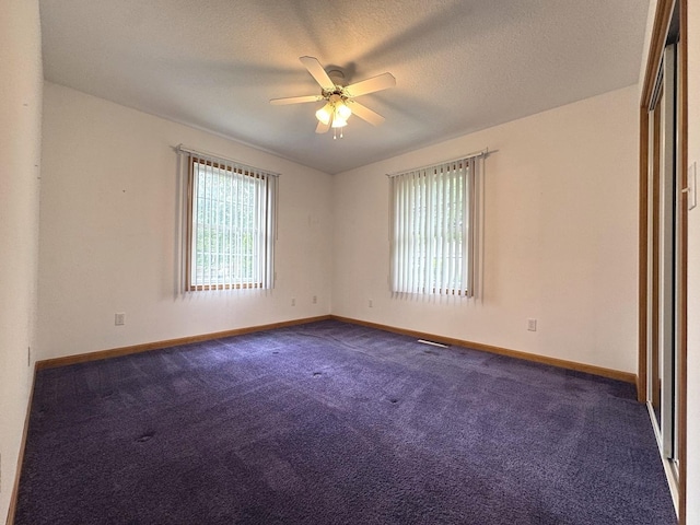 350 Centerpoint Dr N, Bourbonnais, IL 60914 - spare room with a ceiling fan, baseboards, dark carpet, and a textured ceiling