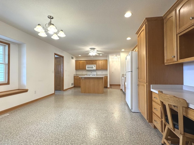 350 Centerpoint Dr N, Bourbonnais, IL 60914 - kitchen featuring white appliances, a center island, light countertops, a chandelier, and baseboards