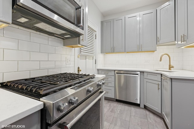 534 W Brompton Ave Unit 1N, Chicago, IL 60657 - kitchen featuring appliances with stainless steel finishes, gray cabinetry, tasteful backsplash, and a sink