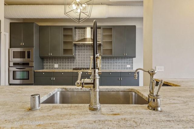 411 W Ontario St Unit 623, Chicago, IL 60654 - kitchen featuring appliances with stainless steel finishes, gray cabinetry, decorative backsplash, and glass insert cabinets