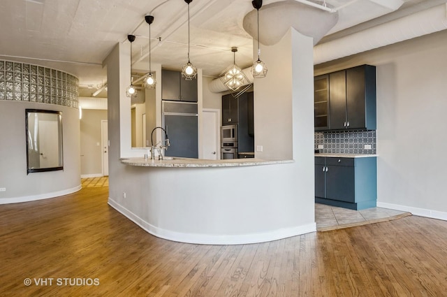 411 W Ontario St Unit 623, Chicago, IL 60654 - kitchen with appliances with stainless steel finishes, wood finished floors, decorative backsplash, baseboards, and a sink