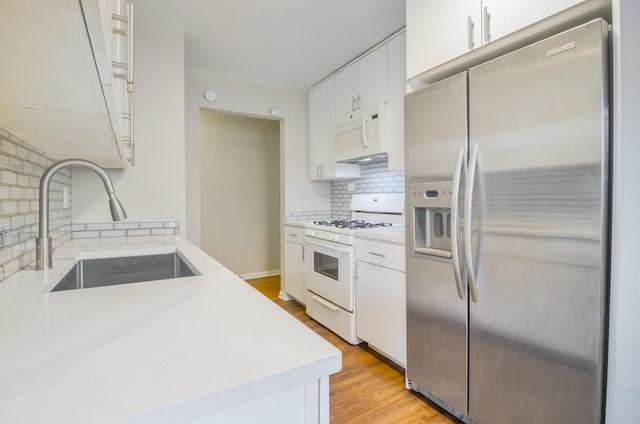 39 W Conti Pkwy Unit 2N, Elmwood Park, IL 60707 - kitchen featuring white appliances, a sink, light countertops, backsplash, and light wood finished floors