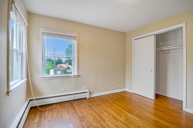 39 W Conti Pkwy Unit 2N, Elmwood Park, IL 60707 - unfurnished bedroom featuring wood finished floors, a baseboard radiator, a closet, and baseboards