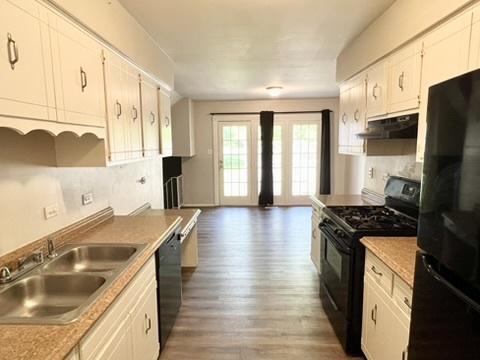 807 Violet Ln, Matteson, IL 60443 - kitchen featuring black appliances, under cabinet range hood, wood finished floors, a sink, and white cabinetry