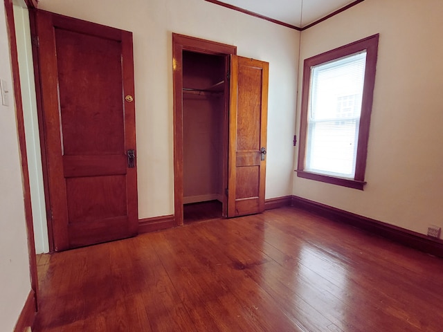 318 W 112th St, Chicago, IL 60628 - unfurnished bedroom featuring wood-type flooring, baseboards, crown molding, and a closet