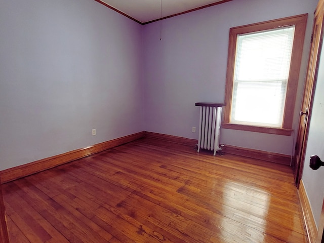 318 W 112th St, Chicago, IL 60628 - empty room with radiator heating unit, ornamental molding, light wood-style flooring, and baseboards