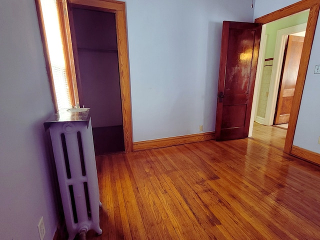 318 W 112th St, Chicago, IL 60628 - unfurnished bedroom with radiator, baseboards, and wood finished floors