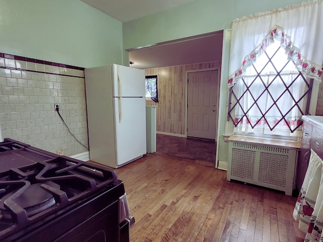 318 W 112th St, Chicago, IL 60628 - bedroom featuring freestanding refrigerator, light wood-style floors, baseboards, and radiator