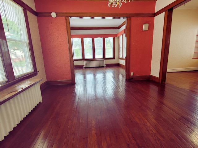 318 W 112th St, Chicago, IL 60628 - empty room with radiator, a textured wall, plenty of natural light, wood-type flooring, and a chandelier