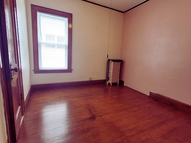 318 W 112th St, Chicago, IL 60628 - empty room with radiator, dark wood-style floors, and crown molding