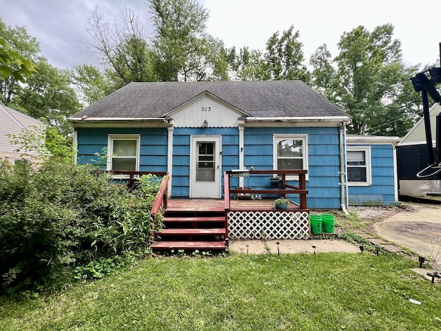 213 Arcadia Dr, Champaign, IL 61820 - view of front of property featuring a deck, a front lawn, and roof with shingles