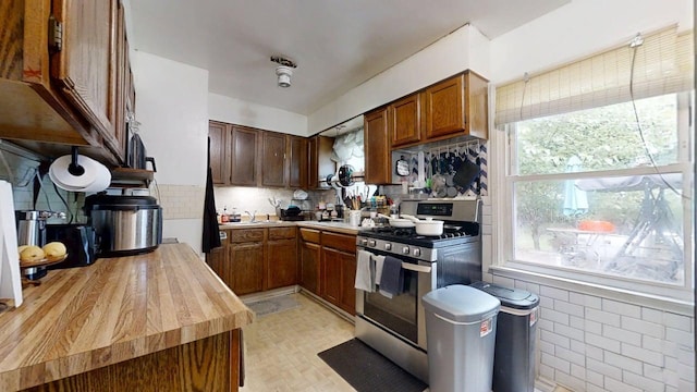213 Arcadia Dr, Champaign, IL 61820 - kitchen with stainless steel gas range, butcher block counters, and decorative backsplash