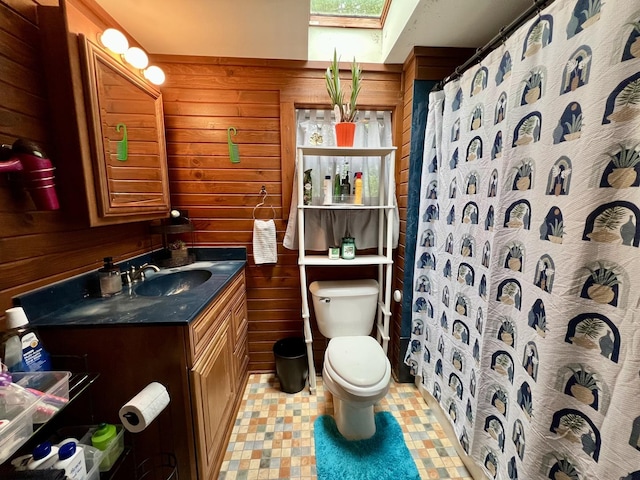 213 Arcadia Dr, Champaign, IL 61820 - full bath featuring a skylight, vanity, toilet, wooden walls, and a shower with curtain