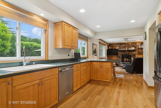 717 Burris Ave, Lake Bluff, IL 60044 - kitchen featuring stainless steel appliances, ceiling fan, open floor plan, a fireplace, and light wood-type flooring