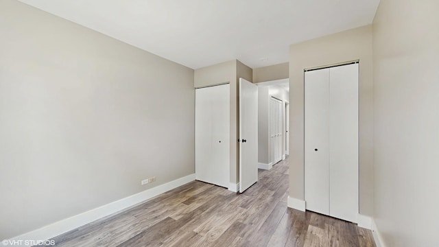 267 Juniper Cir, Streamwood, IL 60107 - unfurnished bedroom featuring two closets, wood finished floors, and baseboards