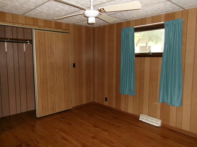 143 W Scott St, Seneca, IL 61360 - empty room featuring wood finished floors, wooden walls, and ceiling fan