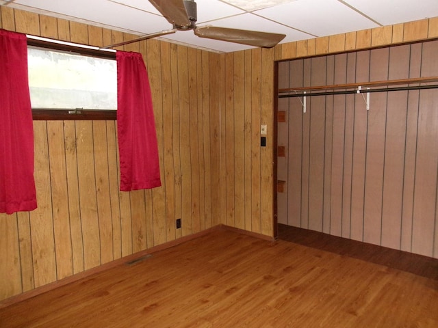 143 W Scott St, Seneca, IL 61360 - spare room featuring wood finished floors, ceiling fan, and wood walls