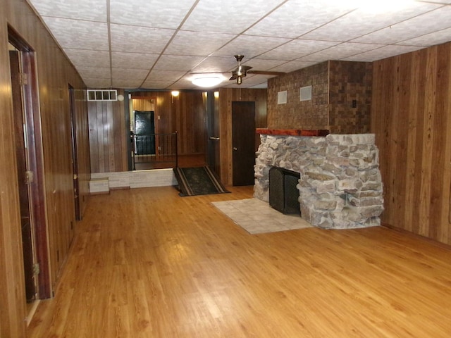 143 W Scott St, Seneca, IL 61360 - unfurnished living room featuring wood walls, light wood-type flooring, and a fireplace