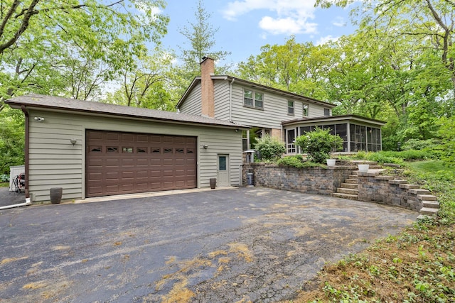 218 Delnor Ave, Saint Charles, IL 60174 - view of side of property featuring a sunroom, a chimney, a garage, and an outdoor structure
