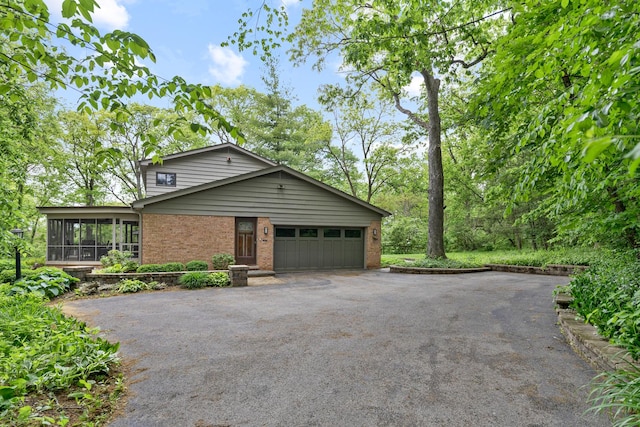 218 Delnor Ave, Saint Charles, IL 60174 - view of front facade featuring driveway, a sunroom, brick siding, and a garage
