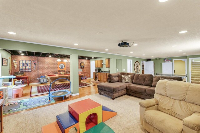 1321 W Ridge Ln, Champaign, IL 61822 - living room with brick wall, recessed lighting, light wood-style flooring, and ornamental molding