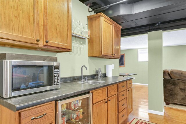 1321 W Ridge Ln, Champaign, IL 61822 - kitchen featuring beverage cooler, stainless steel microwave, a sink, light wood finished floors, and dark countertops