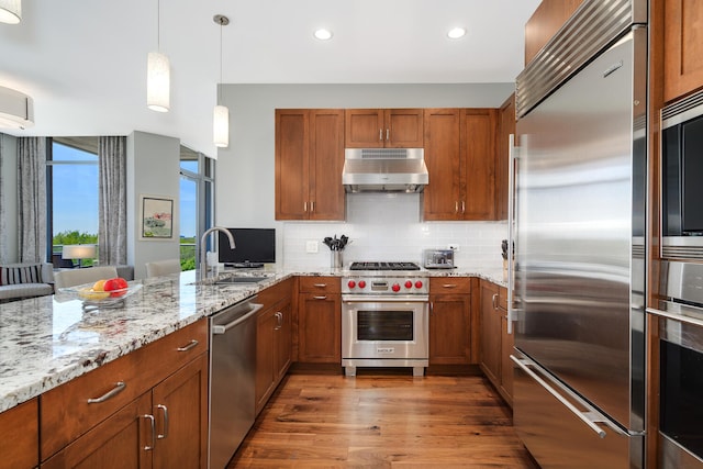 540 W Webster Ave Unit 611, Chicago, IL 60614 - kitchen featuring high end appliances, under cabinet range hood, a sink, brown cabinets, and recessed lighting