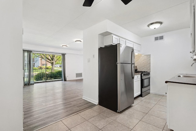 7131 166th St Unit 101, Tinley Park, IL 60477 - kitchen featuring appliances with stainless steel finishes, a sink, light tile patterned flooring, and white cabinetry