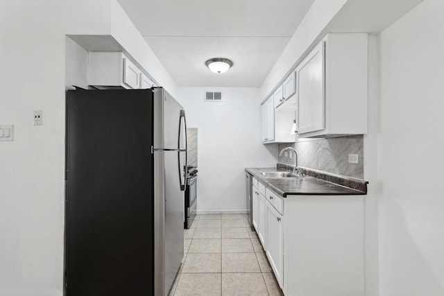7131 166th St Unit 101, Tinley Park, IL 60477 - kitchen with appliances with stainless steel finishes, a sink, decorative backsplash, white cabinets, and dark countertops