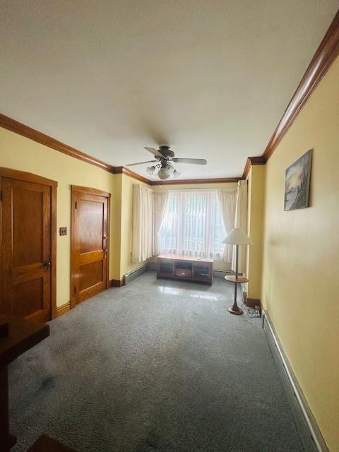 4001 S Albany Ave, Chicago, IL 60632 - unfurnished living room with ornamental molding, carpet flooring, ceiling fan, and baseboards
