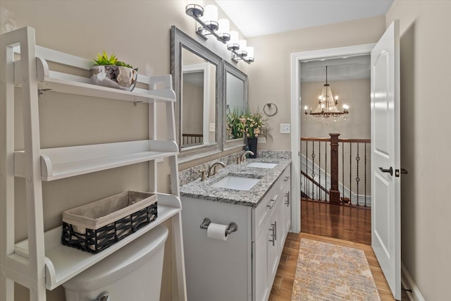 2952 W 100th Pl, Evergreen Park, IL 60805 - bathroom with wood finished floors, toilet, double vanity, and a chandelier