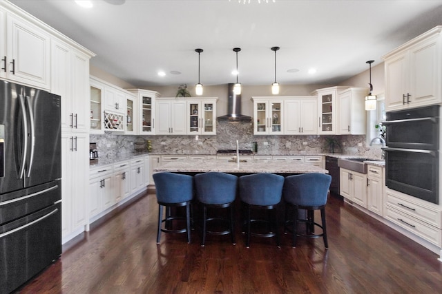 2952 W 100th Pl, Evergreen Park, IL 60805 - kitchen with freestanding refrigerator, wall chimney range hood, a sink, tasteful backsplash, and a kitchen island with sink