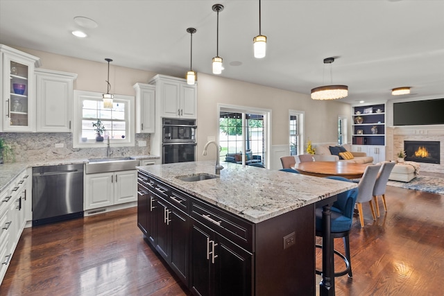 2952 W 100th Pl, Evergreen Park, IL 60805 - kitchen with stainless steel dishwasher, a sink, open floor plan, and white cabinetry