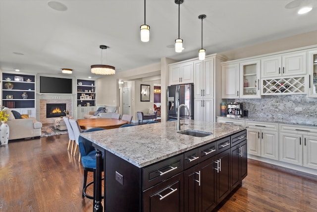 2952 W 100th Pl, Evergreen Park, IL 60805 - kitchen with stainless steel fridge, a sink, white cabinets, a kitchen breakfast bar, and dark wood-style floors