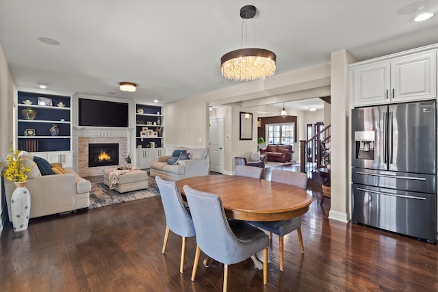 2952 W 100th Pl, Evergreen Park, IL 60805 - dining space with a glass covered fireplace, a chandelier, dark wood-type flooring, baseboards, and built in shelves