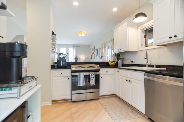 919 W Leland Ave Unit F, Chicago, IL 60640 - kitchen with appliances with stainless steel finishes, a sink, light wood-style flooring, white cabinetry, and dark countertops