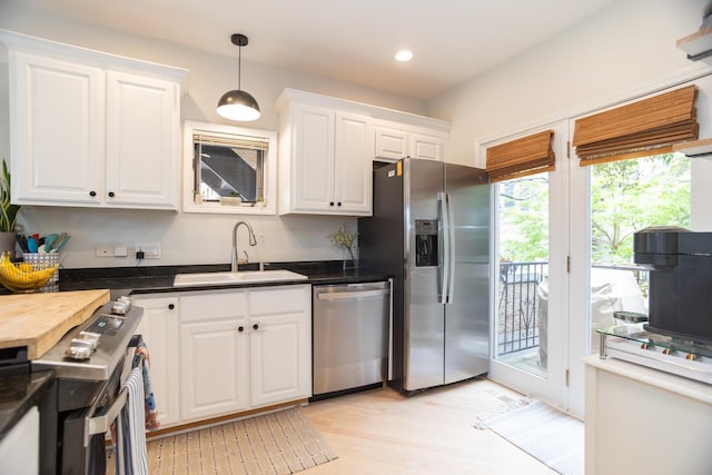 919 W Leland Ave Unit F, Chicago, IL 60640 - kitchen featuring stainless steel appliances, a sink, white cabinetry, dark countertops, and light wood-type flooring