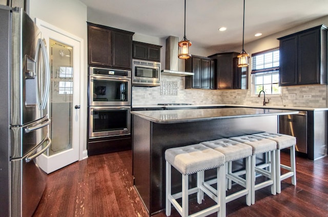 1472 S Saddlebrook Ln, Minooka, IL 60447 - kitchen with appliances with stainless steel finishes, a kitchen bar, dark wood-type flooring, backsplash, and recessed lighting