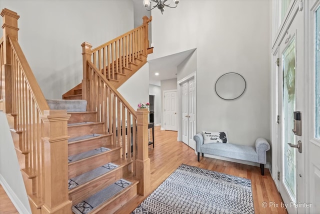 7530 Inverway Dr, Lakewood, IL 60014 - entrance foyer featuring wood finished floors, stairway, a high ceiling, baseboards, and a chandelier