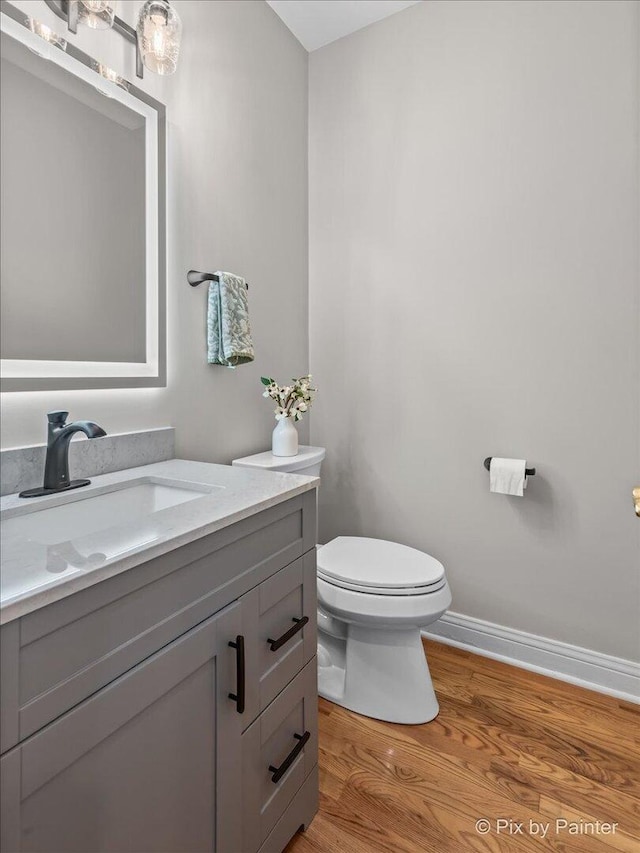 7530 Inverway Dr, Lakewood, IL 60014 - half bath with toilet, vanity, wood finished floors, and baseboards