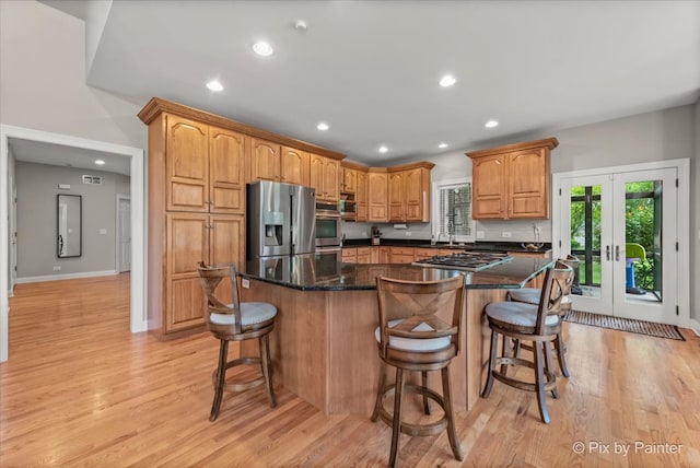 7530 Inverway Dr, Lakewood, IL 60014 - kitchen featuring stainless steel appliances, light wood-style floors, recessed lighting, a kitchen island, and a breakfast bar area