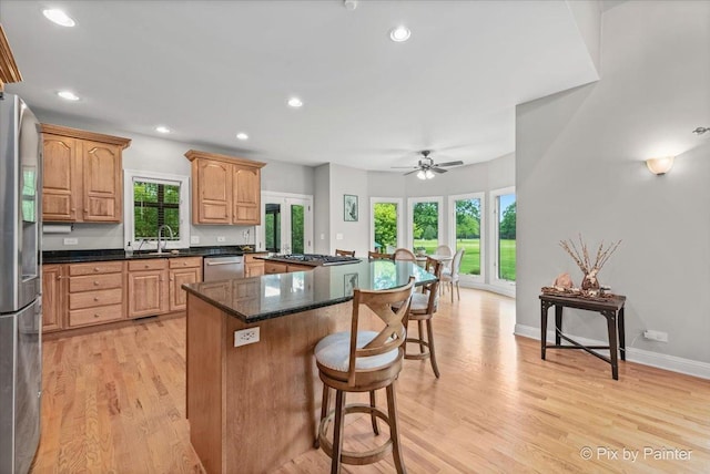 7530 Inverway Dr, Lakewood, IL 60014 - kitchen featuring stainless steel appliances, a breakfast bar area, light wood-style floors, a sink, and ceiling fan
