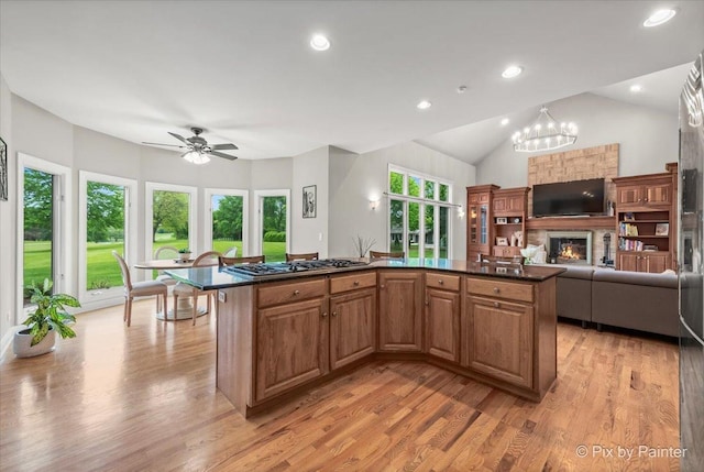7530 Inverway Dr, Lakewood, IL 60014 - kitchen featuring open floor plan, dark countertops, light wood-type flooring, stainless steel gas cooktop, and lofted ceiling