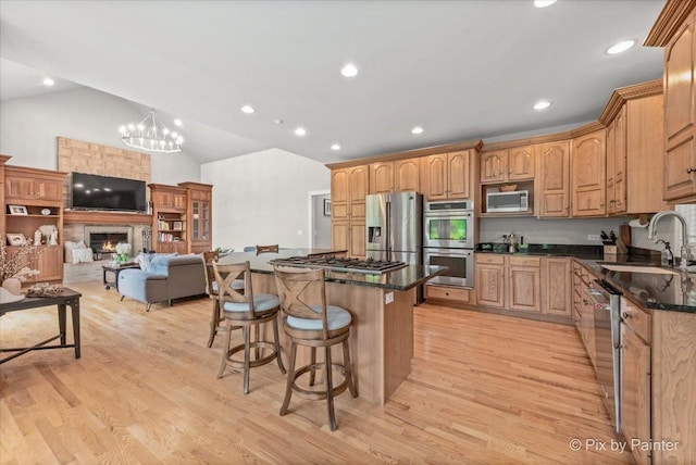 7530 Inverway Dr, Lakewood, IL 60014 - kitchen featuring appliances with stainless steel finishes, a sink, a breakfast bar area, a center island, and light wood-style flooring