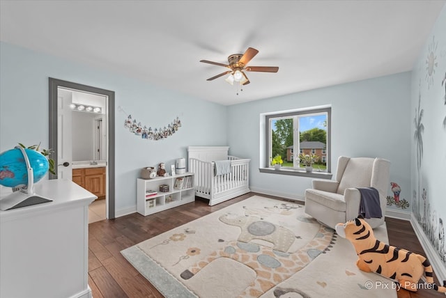 7530 Inverway Dr, Lakewood, IL 60014 - bedroom with dark wood-type flooring, a crib, baseboards, a ceiling fan, and ensuite bathroom