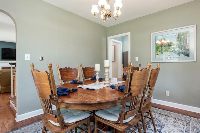 3803 Charles St, Rockford, IL 61108 - dining room featuring arched walkways, wood finished floors, baseboards, and a chandelier