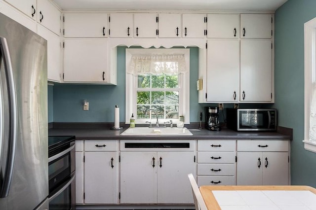 3803 Charles St, Rockford, IL 61108 - kitchen with stainless steel appliances, a sink, white cabinets, and dark countertops