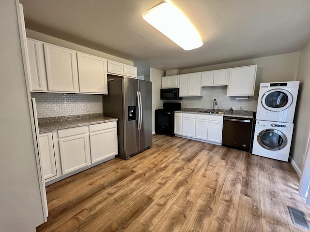 2422 E Washington St, Urbana, IL 61802 - kitchen featuring dishwasher, range, black microwave, stainless steel refrigerator with ice dispenser, and stacked washer / dryer