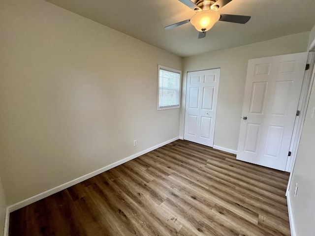 2422 E Washington St, Urbana, IL 61802 - unfurnished bedroom with wood finished floors, a closet, and ceiling fan